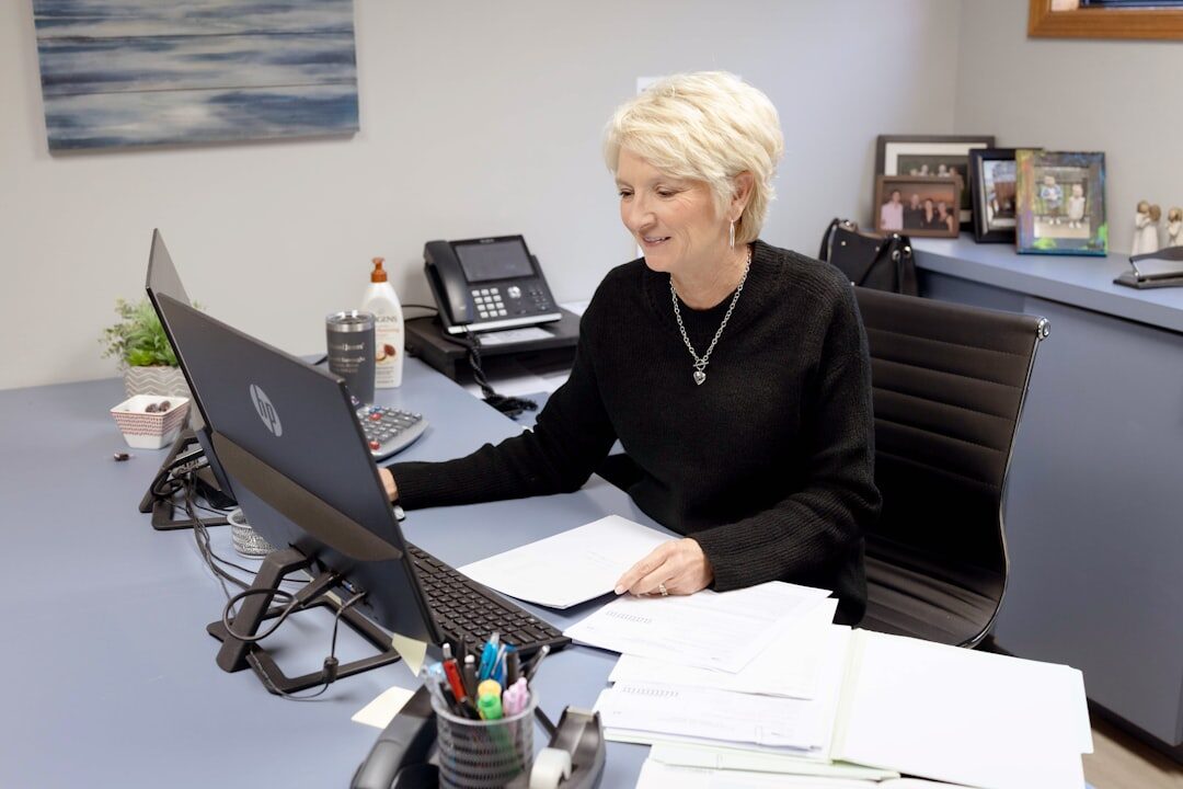 Friendly staff member helping a senior client on the phone