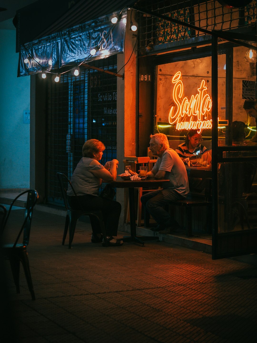 Group of senior friends laughing together at a cafe table